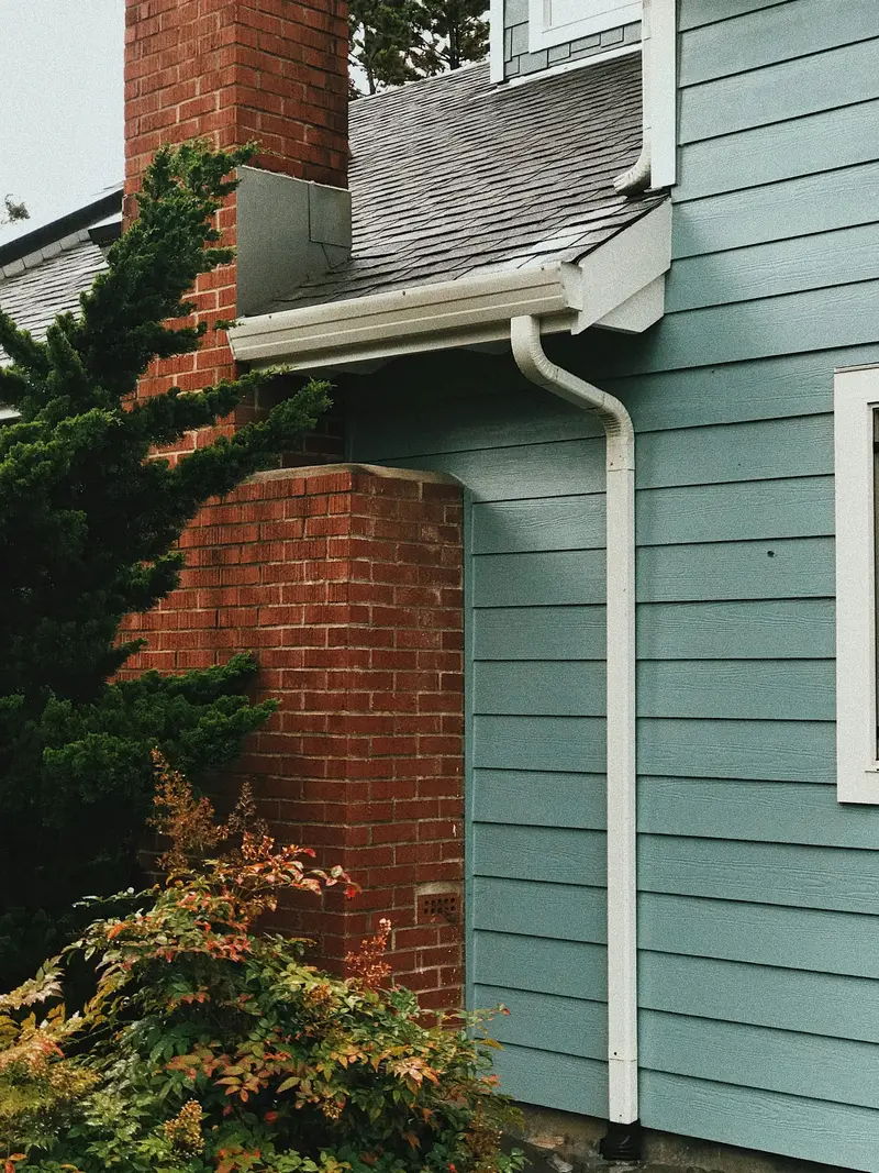 White downspout running down the siding of a house