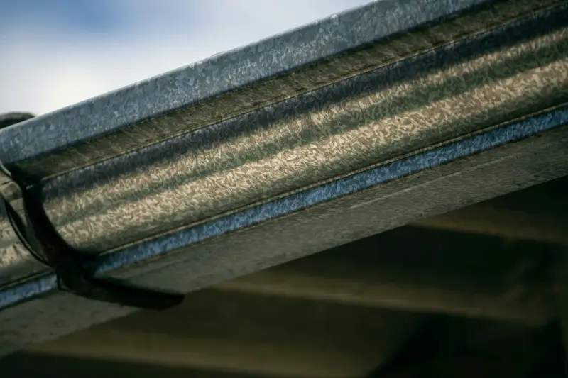 Close-up of a metal gutter run under a roof edge